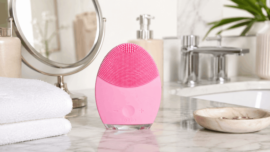 un appareil de nettoyage facial Foreo Luna posé élégamment sur le comptoir d’une salle de bain moderne et lumineuse.